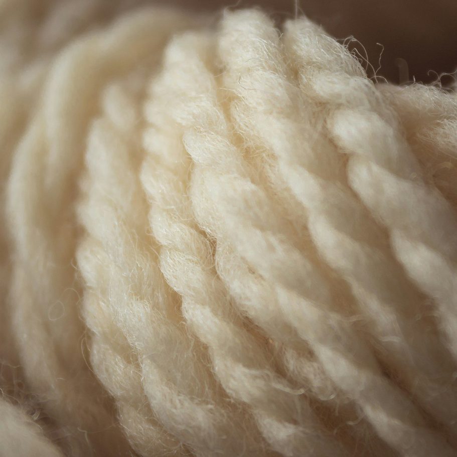 Alpaka Wolle - Alpaka oder Merino – Die wichtigsten Unterschiede Beige, gedrehte Alpaka-Wolle in einer engen Anordnung, weich und fluffig.